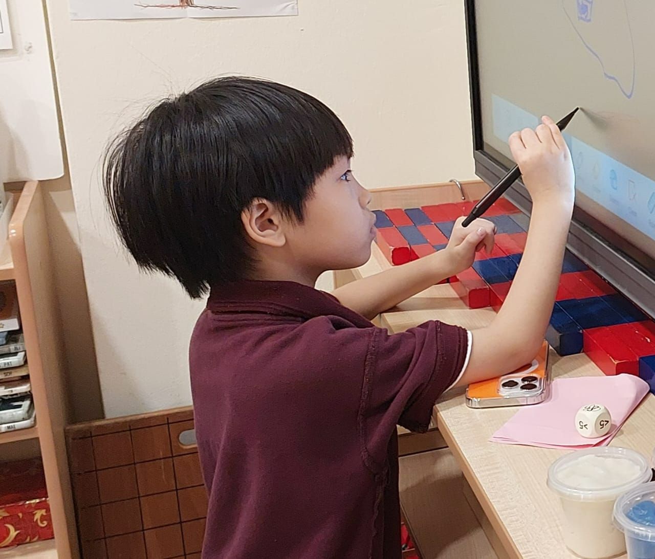 A child learning at Breakthru with a smart board